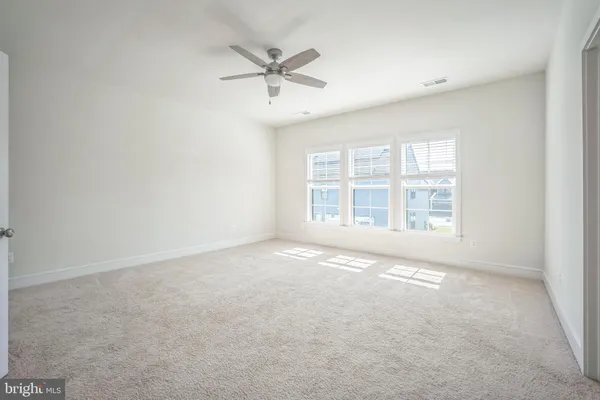 an empty room with windows and ceiling fan view