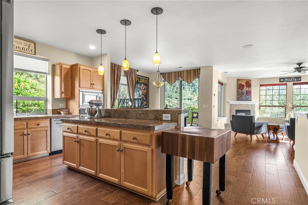 3560 Shadowtree Lane Chico, CA 95928 - Photo 13 of 52 a open kitchen with stainless steel appliances granite countertop a stove a refrigerator a sink dishwasher a dining table and chairs with wooden floor