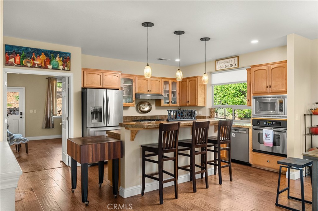 3560 Shadowtree Lane Chico, CA 95928 - Photo 5 of 52 a kitchen with stainless steel appliances kitchen island granite countertop a table chairs and a refrigerator