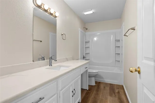 a bathroom with a sink a toilet a tub and shower