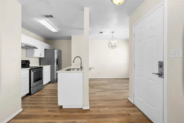 a view of kitchen with sink and refrigerator