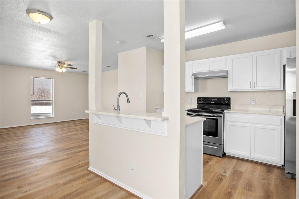 753 Olive Branch Road Weatherford, TX 76087 - Photo 6 of 21 a kitchen with a refrigerator and a stove top oven