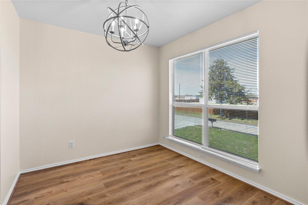753 Olive Branch Road Weatherford, TX 76087 - Photo 8 of 21 an empty room with wooden floor fan and windows