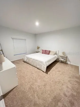 a spacious bedroom with a bed and a cabinets