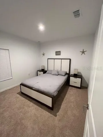 a bedroom with a bed and a lamp