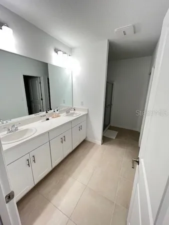 a bathroom with a double vanity sink and mirror