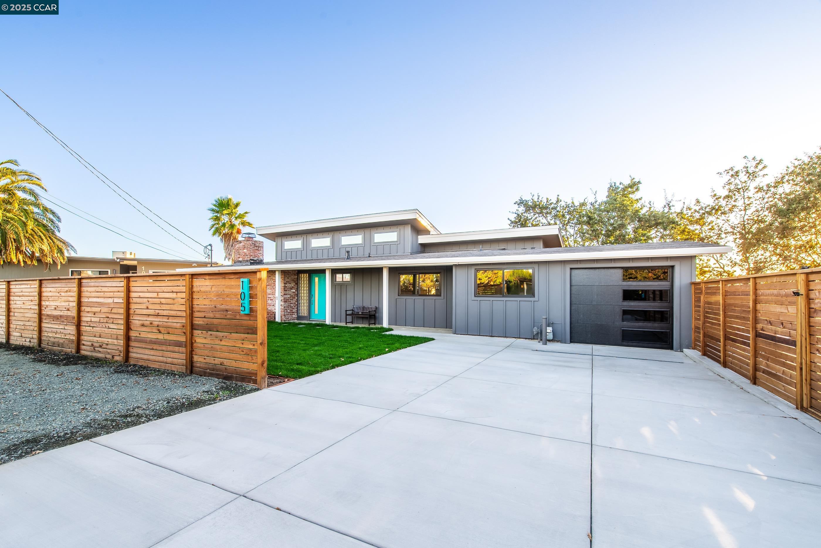 a front view of house with yard and trees in the background