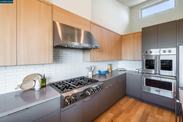 a living room with stainless steel appliances kitchen island furniture and a large window