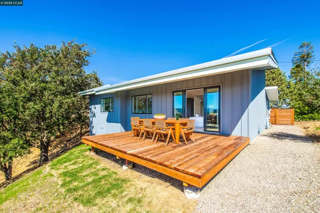 a view of a patio with table and chairs with wooden floor and fence