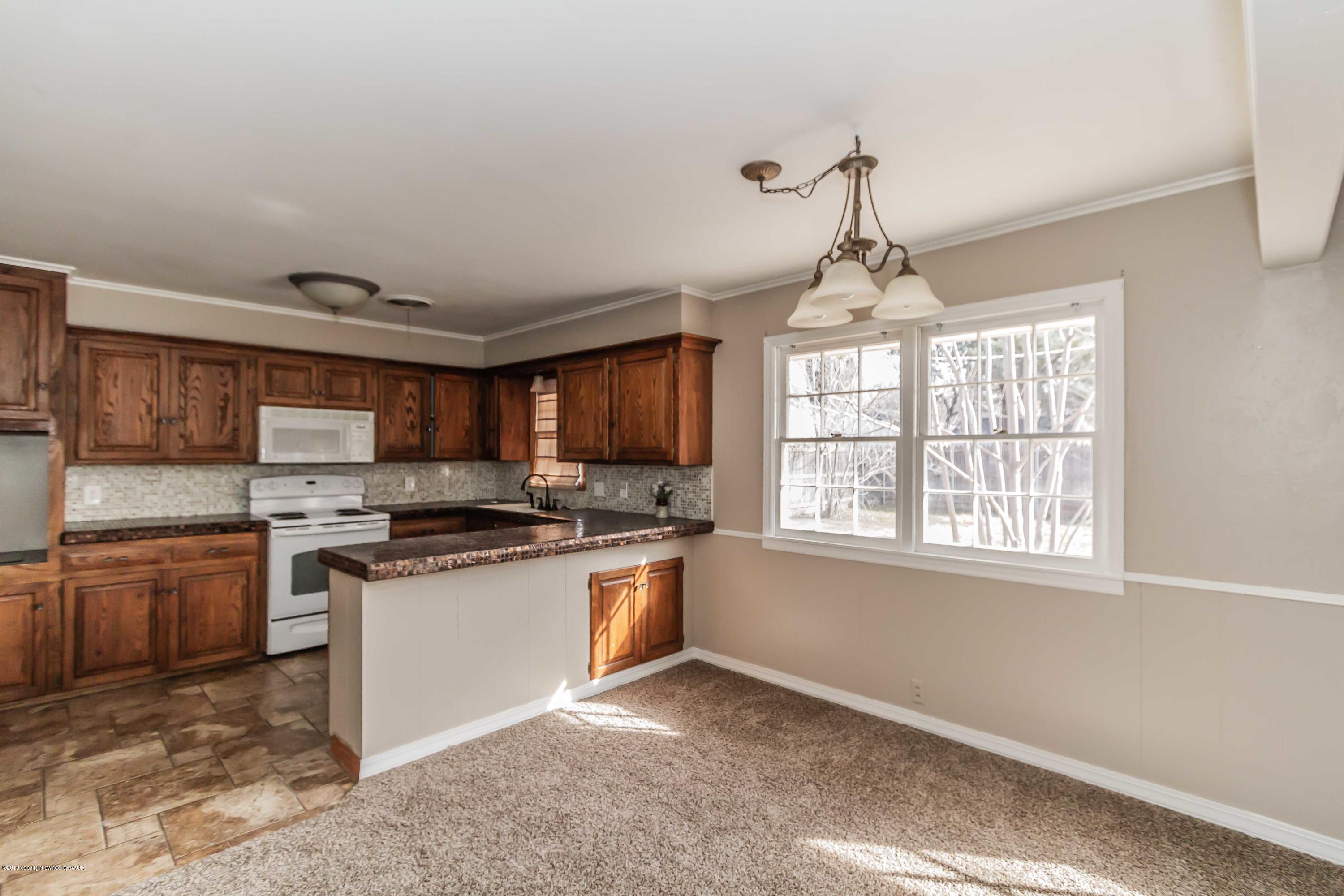 6205 Calumet Road Amarillo, TX 79106 - Photo 12 of 39 a kitchen with stainless steel appliances granite countertop a stove top oven a sink a stove and a window