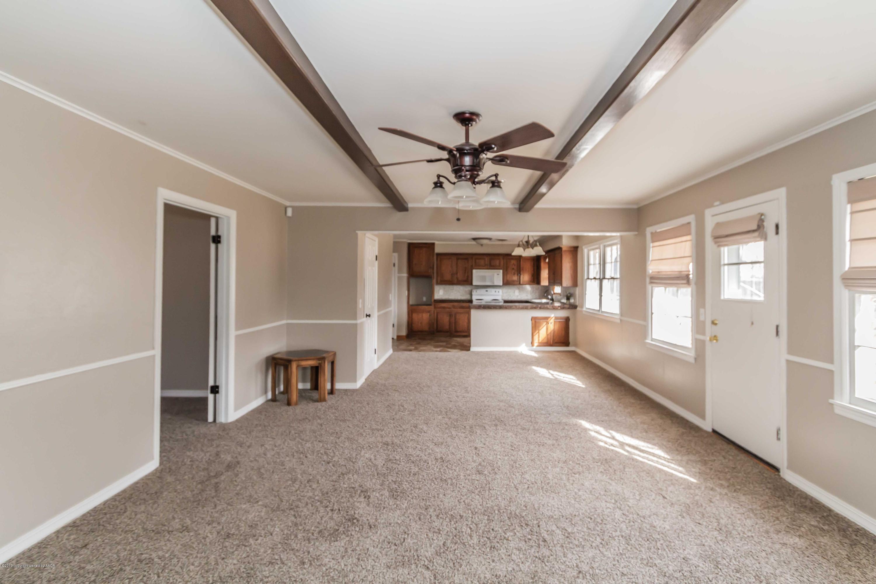 6205 Calumet Road Amarillo, TX 79106 - Photo 19 of 39 a view of a livingroom with a fireplace a ceiling fan and windows