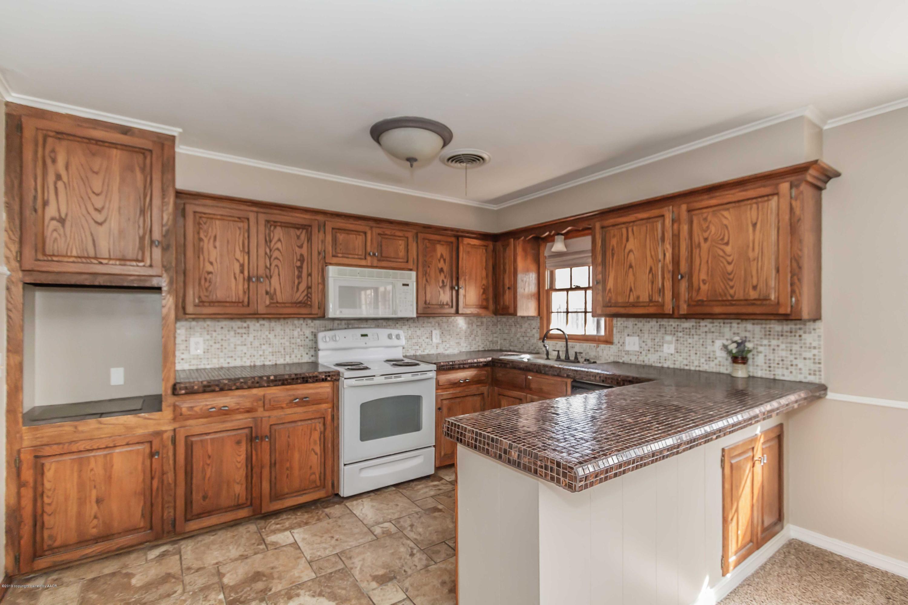 6205 Calumet Road Amarillo, TX 79106 - Photo 3 of 39 a kitchen with a stove sink and cabinets
