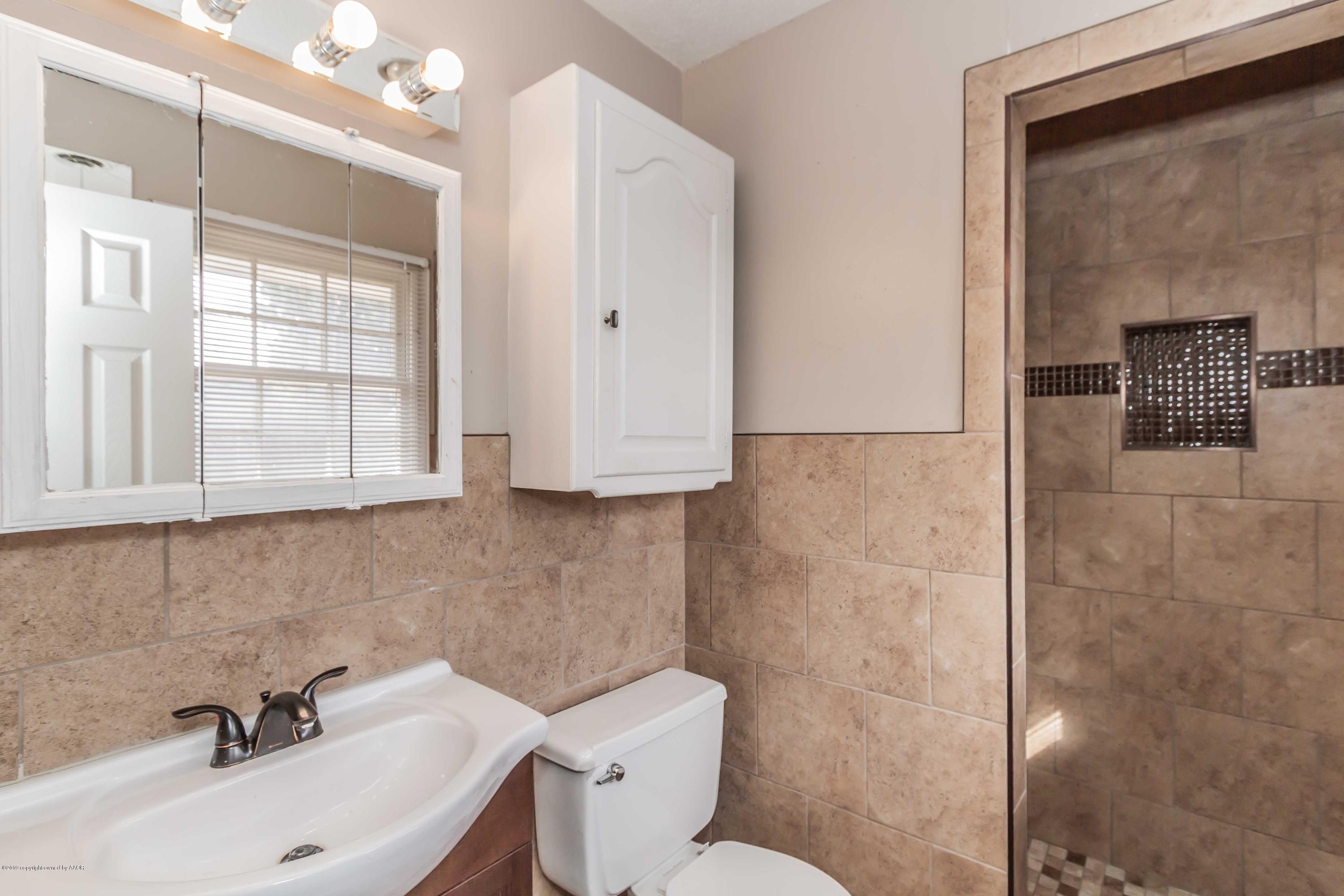 6205 Calumet Road Amarillo, TX 79106 - Photo 25 of 39 a bathroom with a sink a toilet and mirror