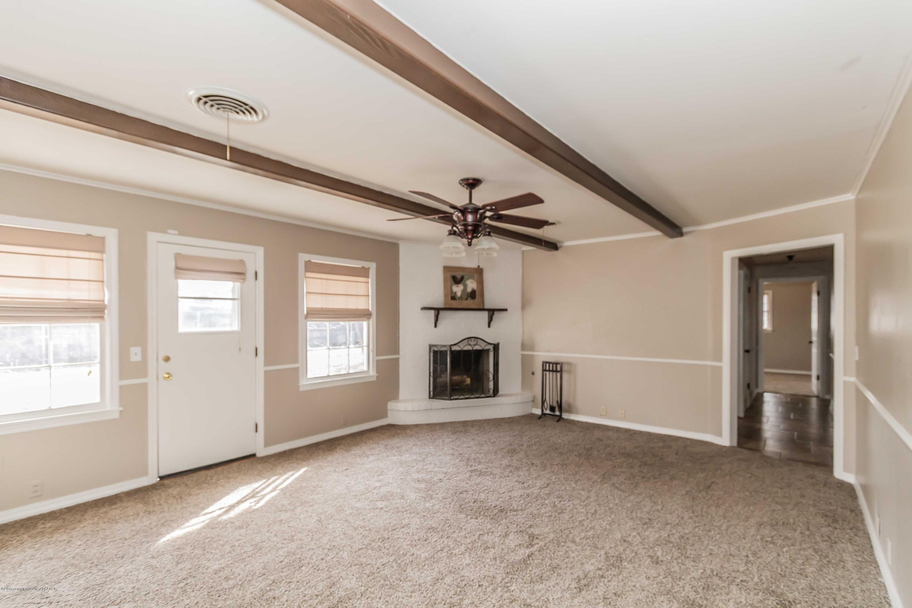 6205 Calumet Road Amarillo, TX 79106 - Photo 4 of 39 an empty room with a fireplace and windows