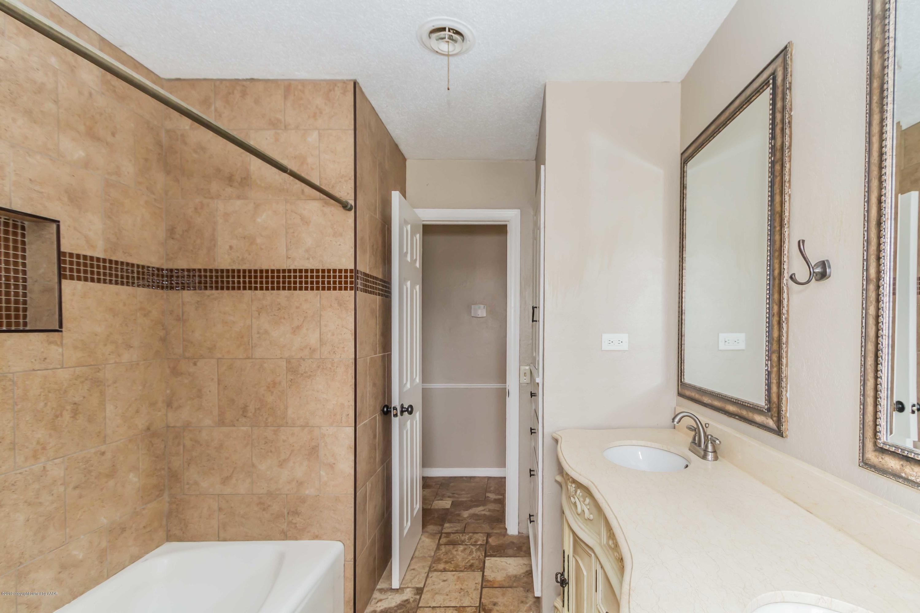 6205 Calumet Road Amarillo, TX 79106 - Photo 34 of 39 a bathroom with a granite countertop sink a mirror and a shower