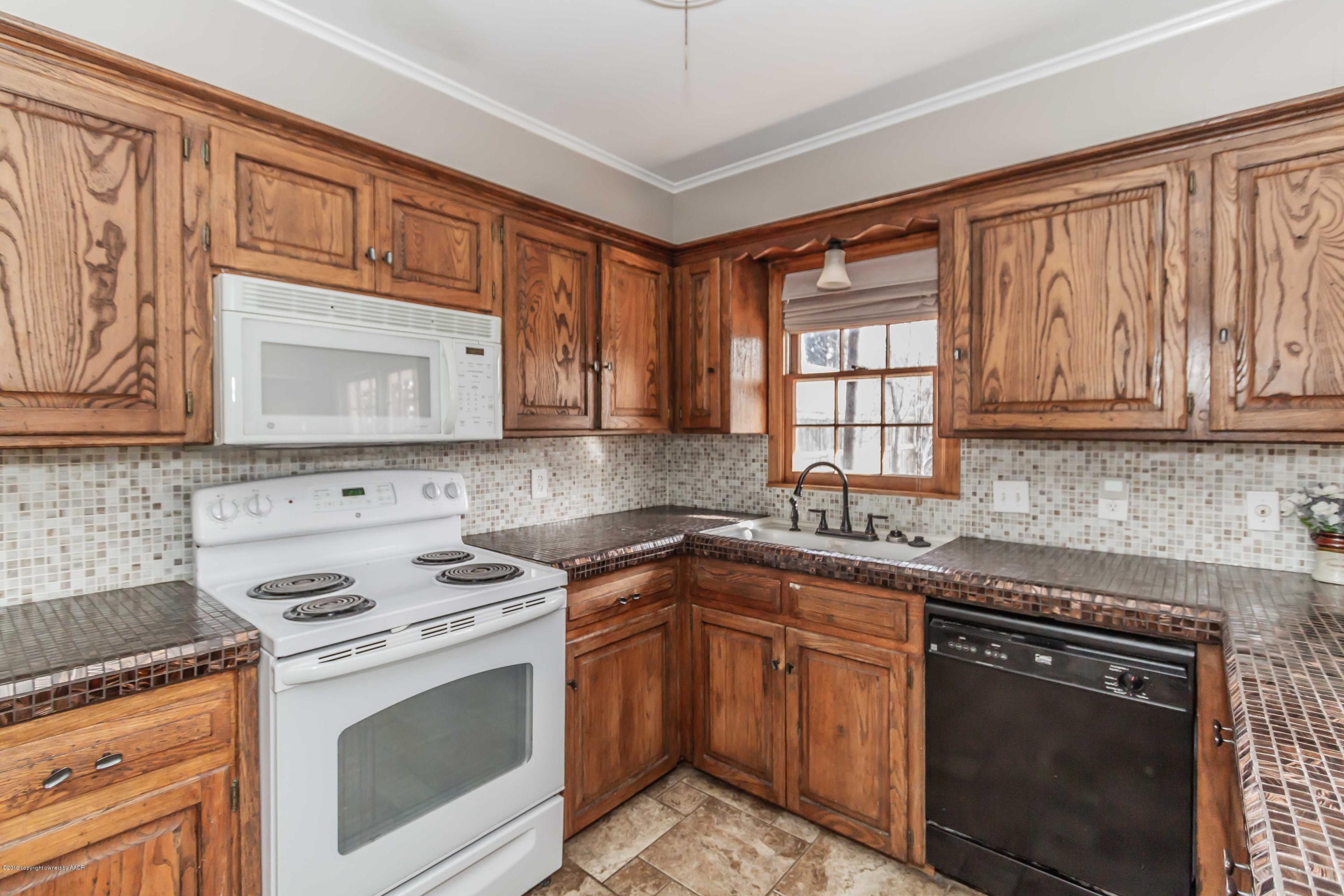 6205 Calumet Road Amarillo, TX 79106 - Photo 7 of 39 a kitchen with stainless steel appliances granite countertop a stove sink microwave and cabinets