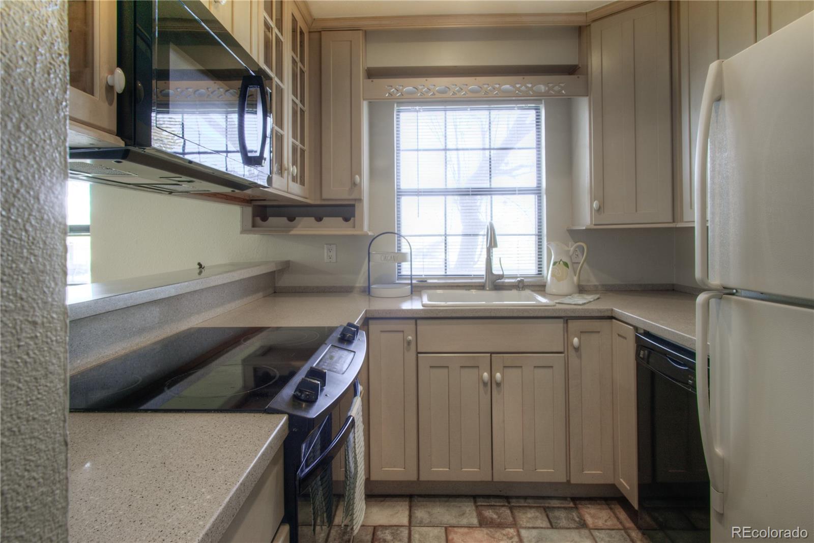 11781 West Elk Head Range Road Littleton, CO 80127 - Photo 11 of 48 a kitchen with stainless steel appliances granite countertop a sink and a refrigerator