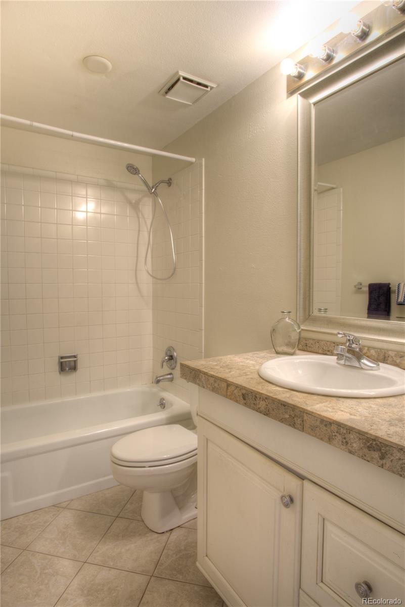 11781 West Elk Head Range Road Littleton, CO 80127 - Photo 24 of 48 a bathroom with a granite countertop sink a toilet and shower