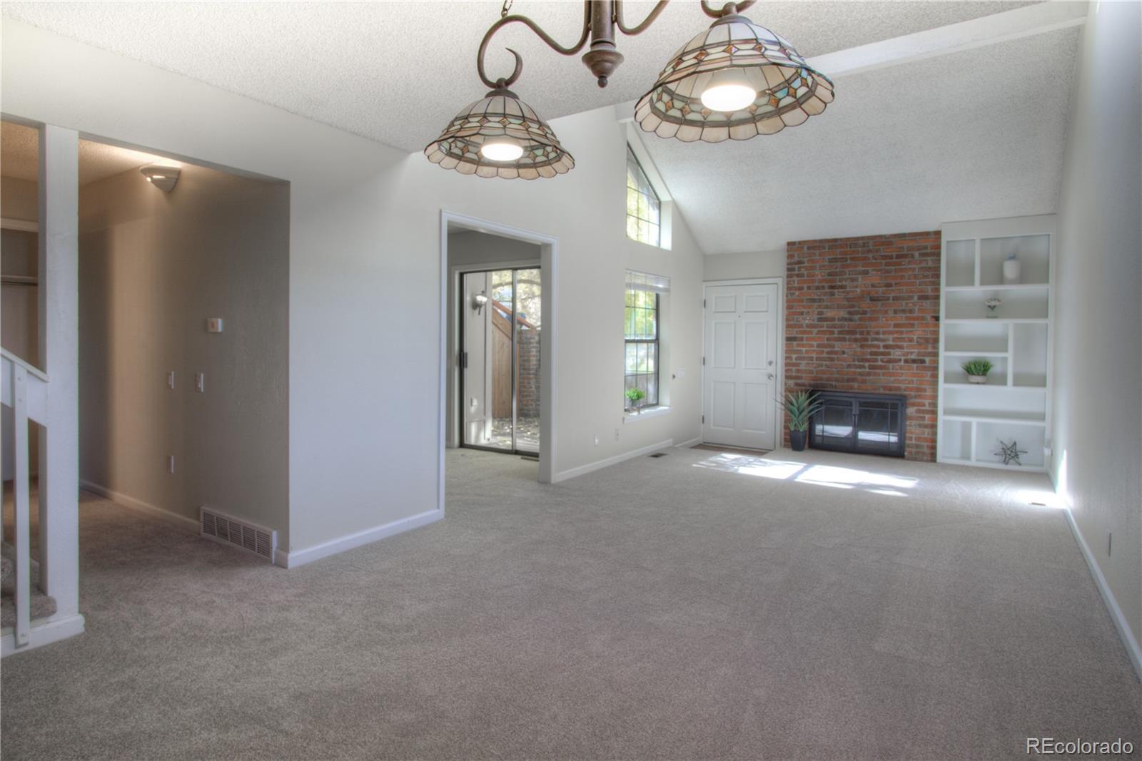 11781 West Elk Head Range Road Littleton, CO 80127 - Photo 6 of 48 an empty room with a fireplace and fan