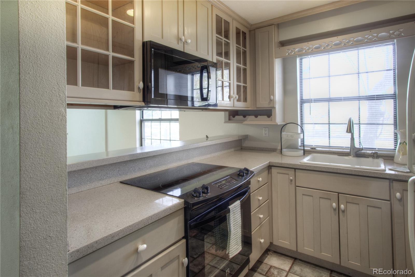 11781 West Elk Head Range Road Littleton, CO 80127 - Photo 10 of 48 a kitchen that has a sink and a stove in it
