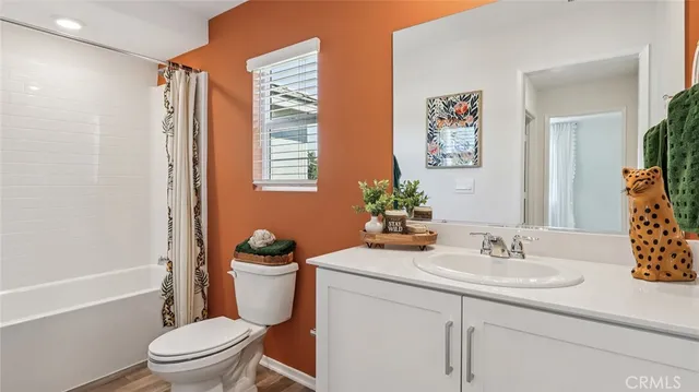 a bathroom with a granite countertop sink a toilet a mirror and shower