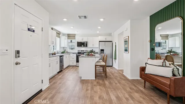 a kitchen with white cabinets and stainless steel appliances