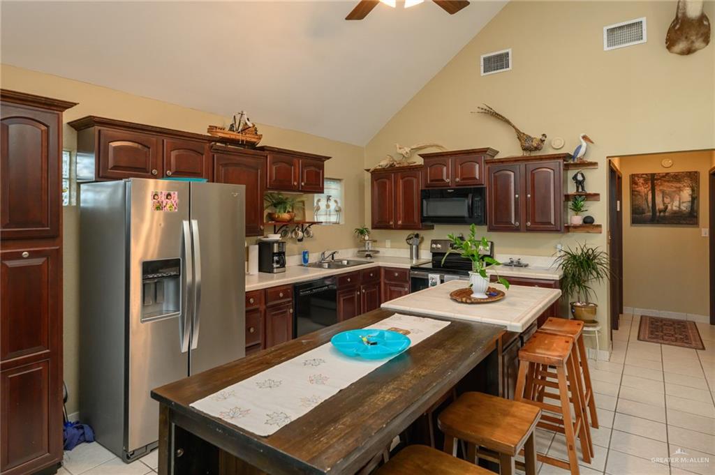 36431 Marshall Hutts Road Rio Hondo, TX 78583 - Photo 6 of 45 a kitchen with stainless steel appliances a table chairs and refrigerator