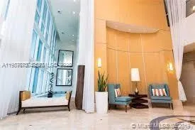 a living room with furniture and a floor to ceiling window