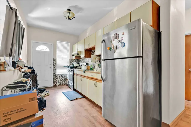 a kitchen with stainless steel appliances a refrigerator sink and white cabinets
