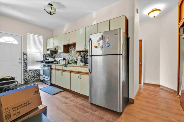 a kitchen with stainless steel appliances a refrigerator sink and white cabinets