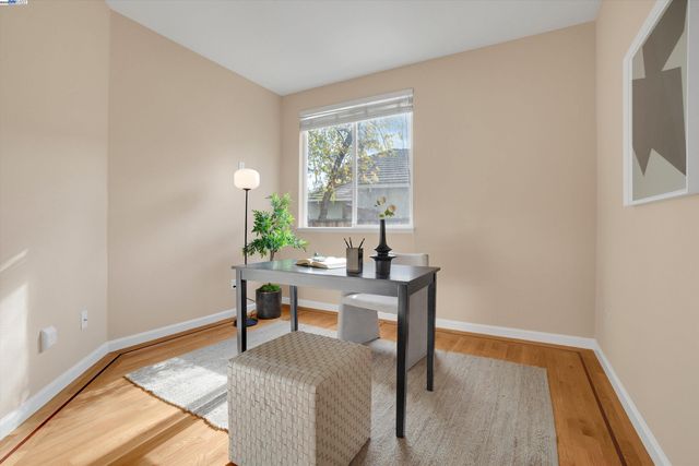 a view of a workspace with furniture and a window