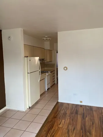 a view of a refrigerator in kitchen and white cabinets