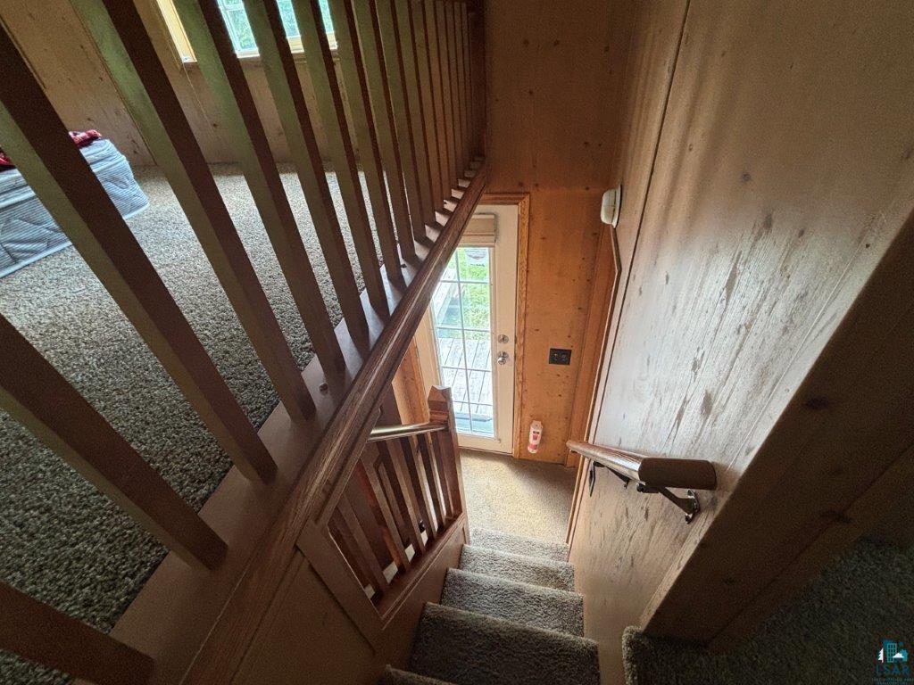9436 Bear Ridge Drive Orr, MN 55771 - Photo 12 of 26 Stairway featuring carpet and wooden walls