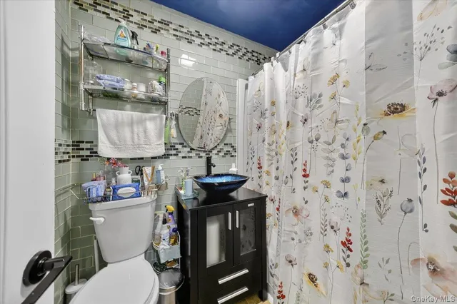 a bathroom with a sink a toilet and shower curtain
