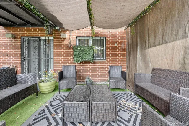 a view of patio with table and chairs potted plants with floor to ceiling window