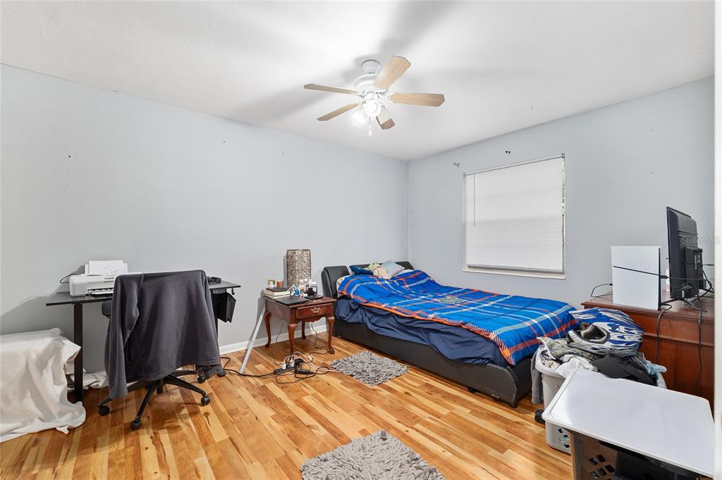 1420 Southwest 42nd Street, Unit B Gainesville, FL 32607 - Photo 21 of 36 a bedroom with two beds and a chandelier