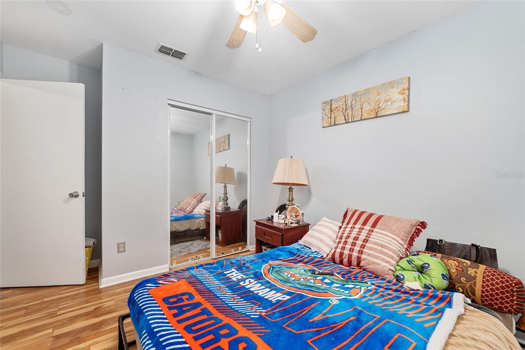1420 Southwest 42nd Street, Unit B Gainesville, FL 32607 - Photo 25 of 36 a bedroom with a bed and a lamp on table
