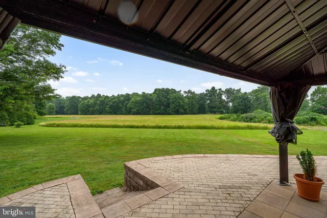 an aerial view of a house with a yard lake and tree in back