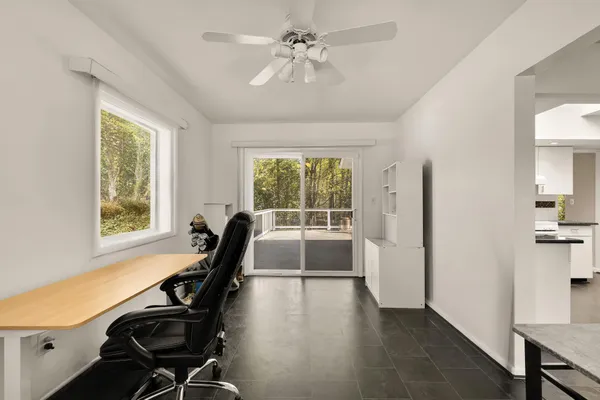 a view of a workspace with furniture and a window