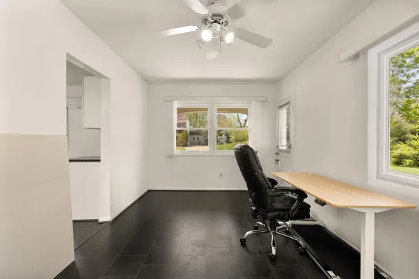 a view of a workspace with furniture and a window