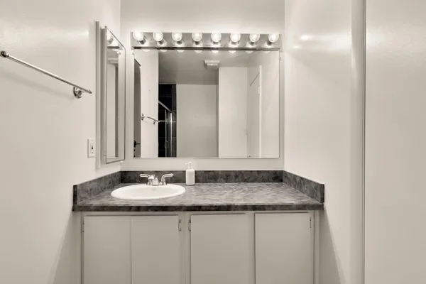 a bathroom with a granite countertop sink and a mirror
