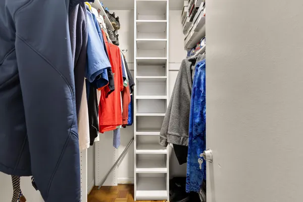 a view of walk in closet with clothes and shoes