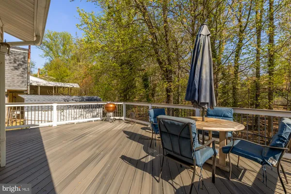 a view of a roof deck with table and chairs and wooden floor