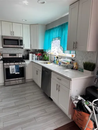 a kitchen with stainless steel appliances granite countertop a stove a sink dishwasher and a microwave oven with wooden floor