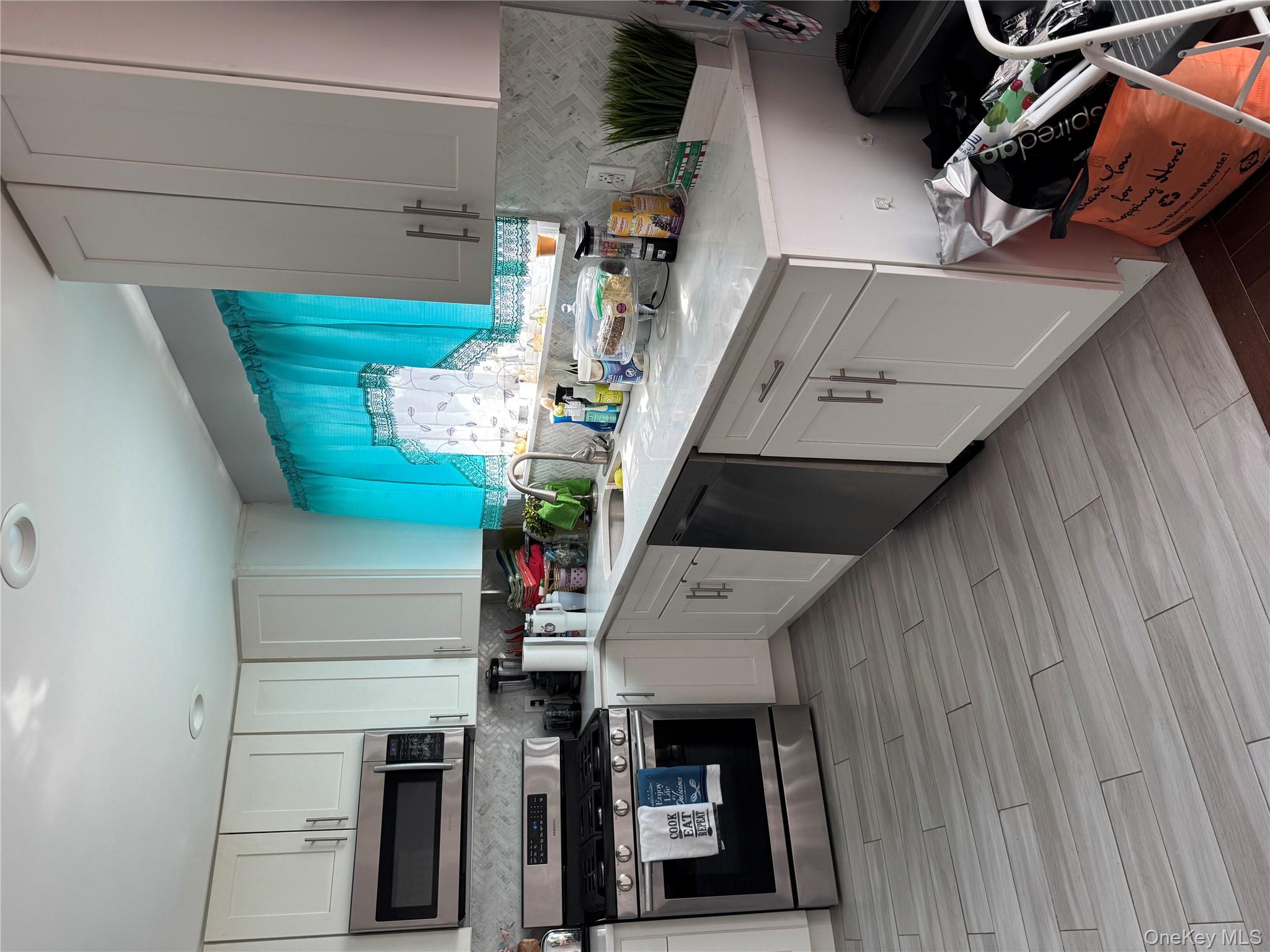 8 Frazier Street Hempstead, NY 11550 - Photo 4 of 7 a kitchen with stainless steel appliances granite countertop a stove a sink dishwasher and a microwave oven with wooden floor