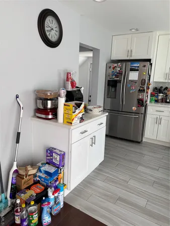 a kitchen with furniture a clock and wooden floor
