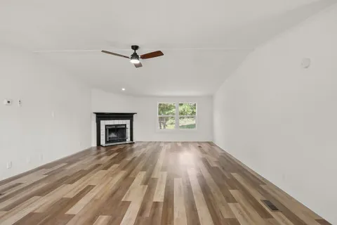 an empty room with windows and fireplace