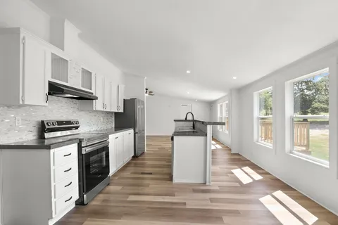 a kitchen with stainless steel appliances granite countertop a refrigerator stove and sink