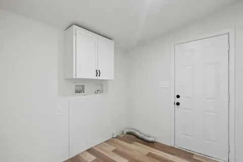 a view of empty room with wooden floor and window