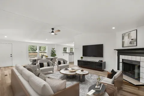 a living room with furniture kitchen view and a fireplace